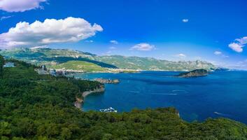 Panorama of bird's eye view of towns of Budva and Becici with hotels and beaches near Adriatic Sea against the backdrop of the Montenegrin Mountains photo