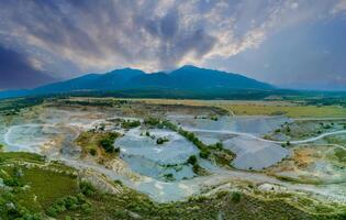 Panorama of sand craters in Montenegro and modern equipment and machines for the extraction of sand against the backdrop of mountains photo