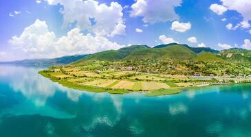 Panorama of fields near Montenegrin villages on the coast of the Adriatic Sea against the backdrop of the Balkan Mountains and sky photo