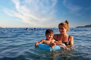 Mother son on inflatable ring sea photo