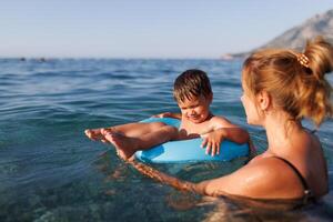 Caring mother rides her son on an inflatable ring in the seaCaring mother rides son on inflatable ring seaCaring mother rides son on inflatable ring sea photo