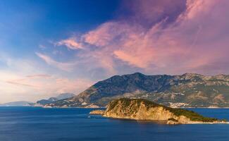 Sunset over an island with mountains photo