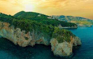 Panorama of cliff with wild vegetation above the waves of the Ad photo