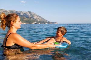 Mother rides on inflatable ring sea photo