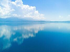 Clouds float across the daytime sky above the horizon with the Adriatic Sea in the light of the sun photo