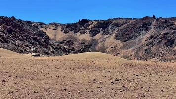 A Vast Barren Landscape Featuring Rocky Terrain Stretching Under a Clear Blue Sky Above photo