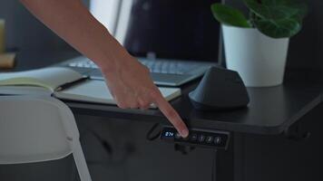 Womans finger pressing control panel to adjust desk height video