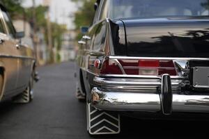 The tail lights, turn signals, and chrome accents on the rear of classic cars exude vintage charm and sophisticated design.b photo