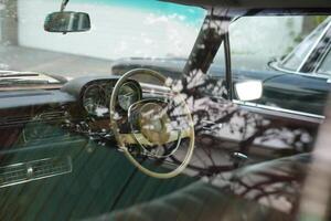 Vintage Classic car steering wheel, with chrome and leather textures in sharp detail, showcases the quality and precision of automotive craftsmanship under natural light.eq photo