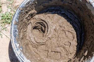 Closeup of a bucket of fresh mortar being prepared for laying bricks photo