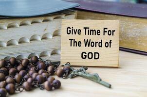 Give Time For The Word of God text on wooden block with Holy Bible and Holy Rosary background. Christianity concept photo