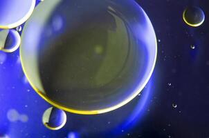 Top view of extreme close up of oil bubbles with gradient light yellow background photo