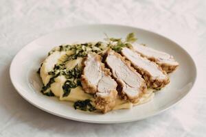 a perfectly sliced chicken schnitzel with creamy mashed potatoes photo