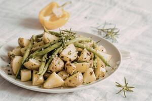 a close-up view of roasted potatoes and green beans photo