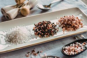 Assorted gourmet salts on a plate photo