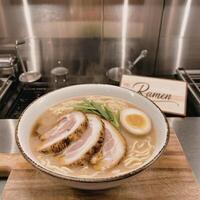 A bowl of ramen with meat and an egg photo