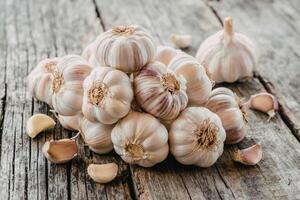Fresh bulbs of garlic stacked on wooden gray background photo