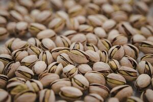 A photo of a pile of pistachios, with the majority still in their shells