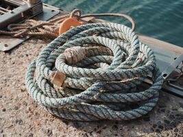 Closeup of coiled fishing rope lying on a quayside photo