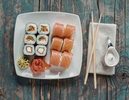 Plate with rolls, wasabi and ginger on a wooden background photo