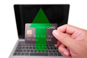 Hand holding credit card with upward arrow, symbolizing financial growth and increased spending. photo
