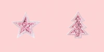 Minimal Merry Christmas and Happy New Year greeting card with pink toy Christmas tree and star with shiny sequins photo