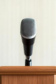 Microphone on a wooden podium ready for a speech or presentation. photo
