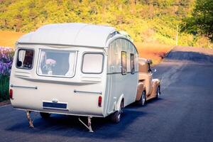 Retro classic caravan or recreational vehicle motor home trailer parked at parking area, vintage colour image. photo