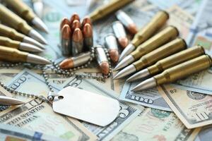 The medallion of a soldier and cartridges lies on dollar bills photo
