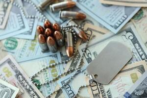 The medallion of a military soldier and cartridges on dollar bills photo