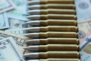 Yellow cartridges and bullets on dollar bills photo