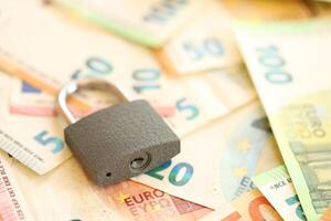 Euro banknotes with lock on table photo
