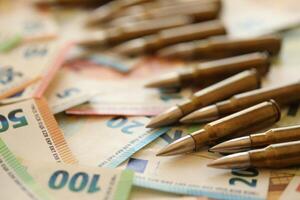 Golden cartridges and big pile of euro money bills photo