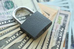 USD Dollar bills and a closed lock as a concept for imposing economic sanctions. photo