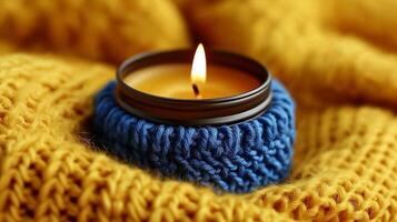 A candle is sitting on a yellow sweater photo