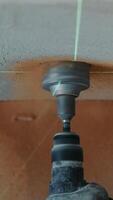 Construction worker drills a hole in the wall under a socket while aligning it with a laser level to ensure precise positioning of the future electrical outlet video