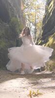 Bride runs between coastal rocks, smiling into the lens. Backlit by the sun, her dress glows with golden flares as she enjoys the joy of the wedding day. video