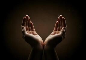 Hands reaching out to the sky, with a dark background photo