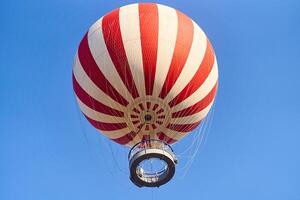 Budapest, Hungary - February 10, 2023. View of a red and white hot air balloon on a blue sky background photo