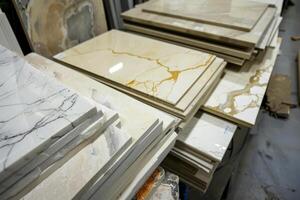A collection of marble slabs featuring various colors and patterns stands stacked side by side in a store, ready for selection photo