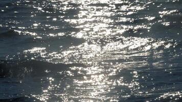 Abstract ocean waves and sun sparkles, slow motion video