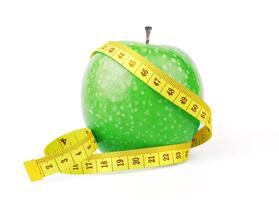 Green apple with yellow measuring tape photo