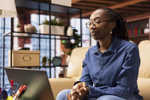Woman focused on a workshop to learn new skills from her apartment, interacting with the tutor on online call. Ambitious girl attend an interactive learning session for personal development. photo