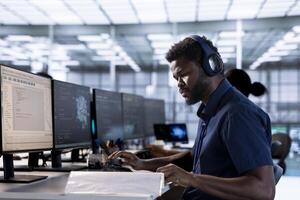 Server room programmer listening music, looking over paperwork after creating high performance AI systems on PC. Engineer in data center wearing headphones checking artificial intelligence documents photo