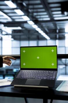 Technicians in data center using green screen mockup laptop, inspecting server clusters, updating network topologies. IT experts using chroma key notebook, ensuring stable operations photo