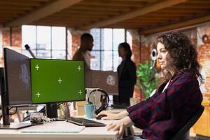 AI startup office software developer using green screen PC, implementing machine learning algorithms. Artificial intelligence tech venture worker working to fix code bugs on chroma key computer photo