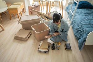 a student woman sitting on the floor with boxes and other items photo