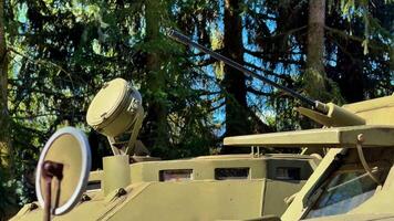 Military Armored Vehicle Positioned in a Dense Forest Setting, Ready for Operations photo