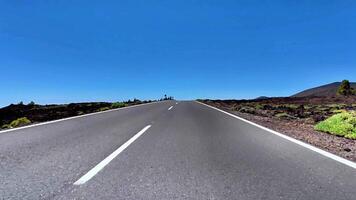 A Scenic Open Road Running Through a Beautiful Lush Landscape Beneath a Clear Blue Sky photo