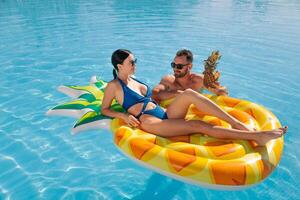 Couple on pineapple pool float photo